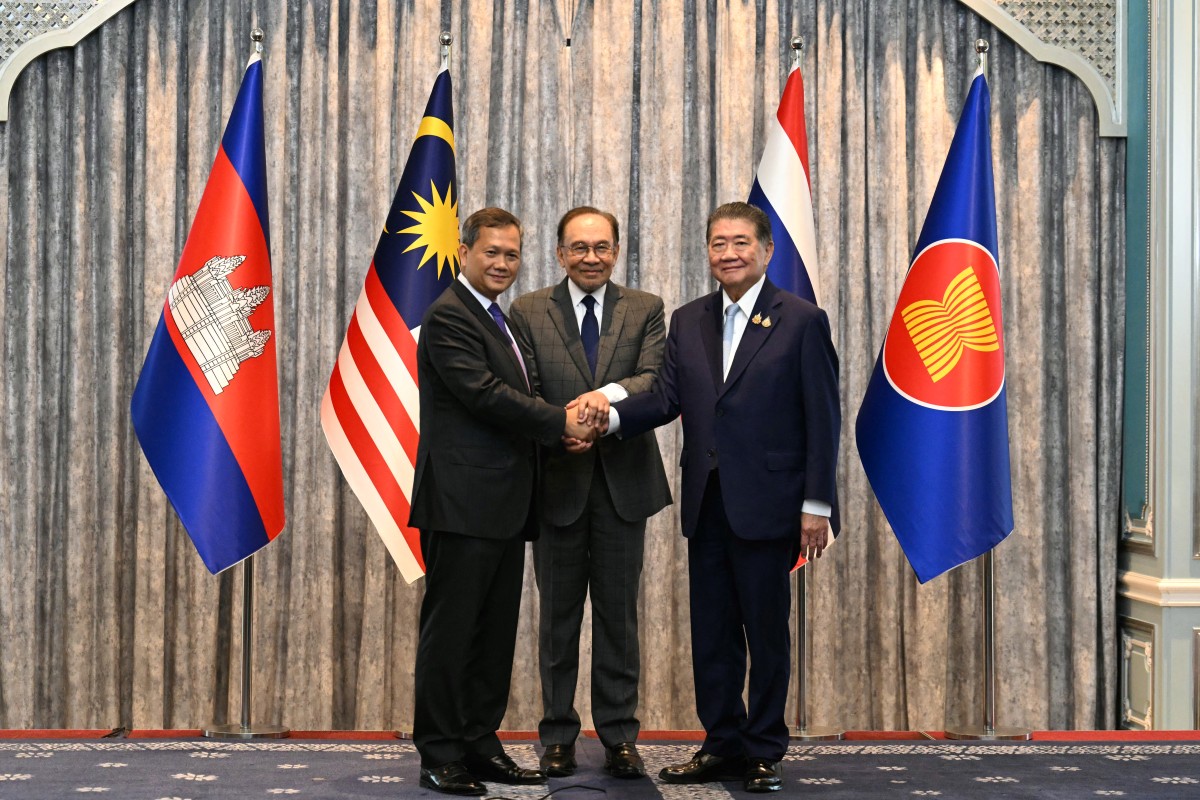 El primer ministro de Malasia, Anwar Ibrahim (centro), el primer ministro de Camboya, Hun Manet (izq.), y el primer ministro interino de Tailandia, Phumtham Wechayachai (der.), posan para fotos mientras se estrechan la mano tras una conferencia de prensa posterior a las conversaciones sobre un posible alto el fuego entre Tailandia y Camboya en Putrajaya el 28 de julio de 2025