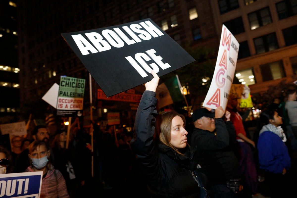 Personas con pancartas marchan en protesta contra la llegada de la Guardia Nacional de Texas y agentes del Servicio de Inmigración y Control de Aduanas (ICE) al centro de Chicago, Illinois, el 8 de octubre de 2025. Chicago, la tercera ciudad más grande del país, se ha convertido en el último foco de tensión en la ofensiva del ICE, que ha generado acusaciones de abusos de derechos humanos y numerosas demandas.